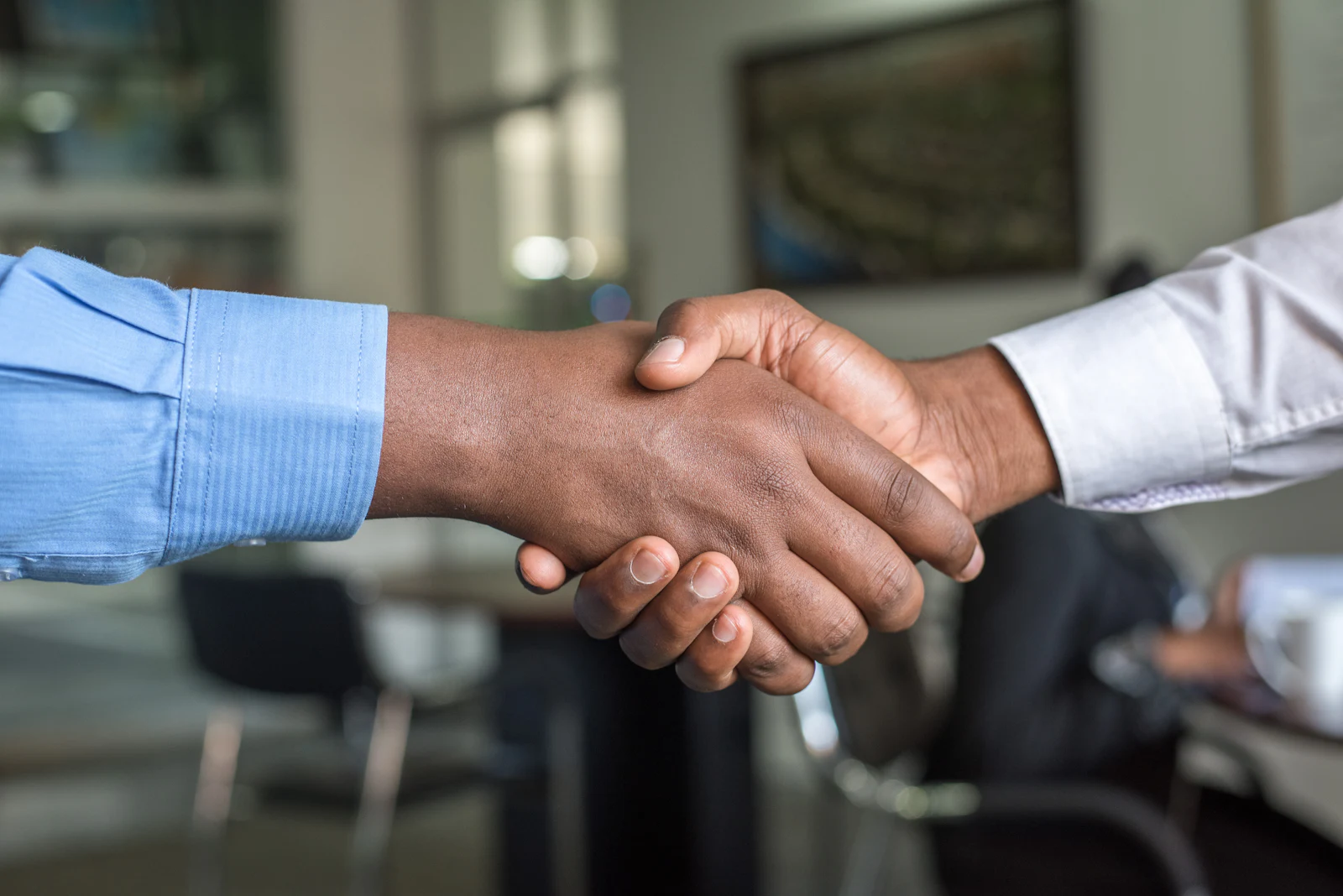 Manzavi and client shaking hands on a partnership